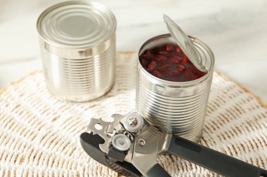 Konserve açacağı ve fasulye konserveleri beyaz masada, yakın plan.