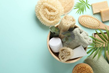 Açık mavi zemin üzerinde lif süngerleri ve çiçek dekoru olan düz konum, metin için boşluk