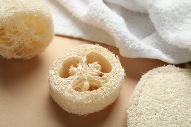 Bej arka planda doğal lif süngeri ve havlu, yakın plan.