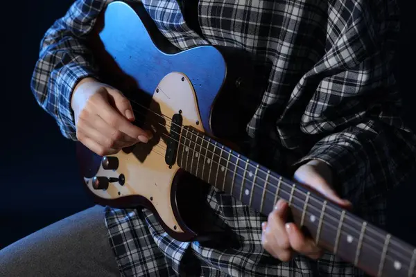 Siyah arka planda gitar çalan kadın, yakın plan