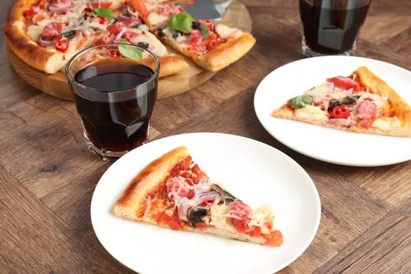 Ahşap masada servis edilen ince füme sosisli, lezzetli pizza dilimleri.