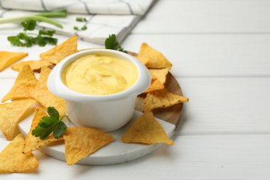 Lezzetli bir peynir sosu ve beyaz ahşap masada cips, yakın plan. Metin için boşluk