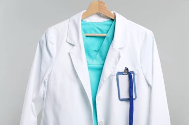 Gri arka planda askısı olan doktorun ceketi