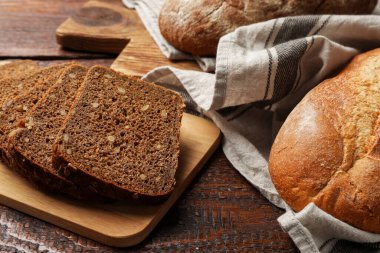 Tahta masadaki farklı taze ekmek türleri, yakın çekim.