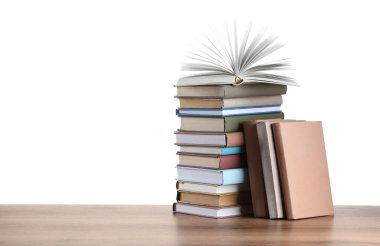 Beyaz arkaplana karşı ahşap masadaki eski kitaplar yığını