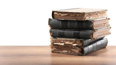 Tahta masadaki eski kitaplar beyaz arka plana karşıdır
