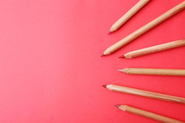 Kırmızı arka planda farklı dudak kalemleri, düz yatış. Metin için boşluk