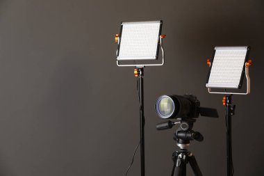 Profesyonel ışıklandırma ekipmanı ve gri arka planda kamera. Metin için boşluk