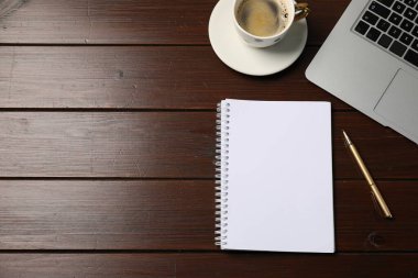 Defter, kalem, kahve ve dizüstü bilgisayar tahtada, düz yerde. Metin için boşluk
