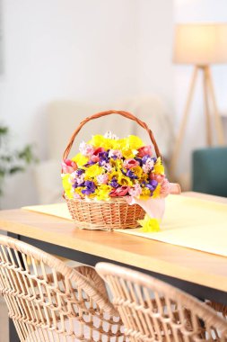 Yemek odasındaki sepetin üzerinde güzel çiçekler var.