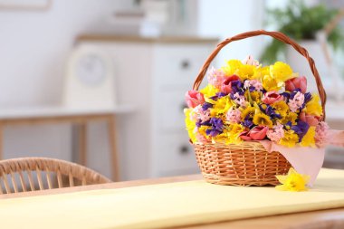 İçerideki masada güzel çiçekler olan hasır sepet. Metin için boşluk