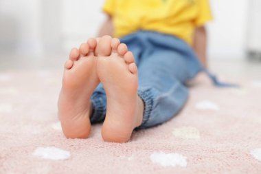 Evdeki yumuşak halıdaki kız, yakın plan.