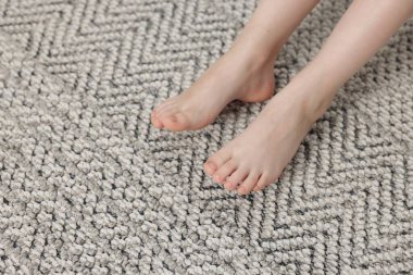 Evdeki gri halıdaki kız, manzaranın üstünde.