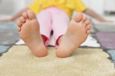 Evdeki yumuşak halıdaki kız, yakın plan.