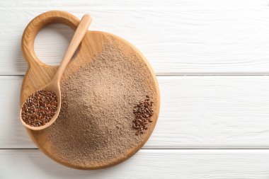 Keten tohumu unu ve kaşıkla beyaz ahşap masa, üst manzara. Metin için boşluk