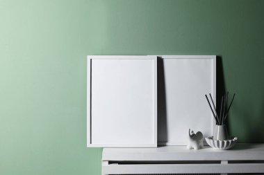 Boş çerçeve ve beyaz rafta soluk yeşil duvarın yanında diğer dekorlar, metin için boşluk