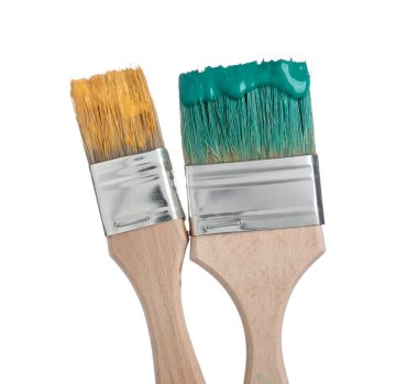 Yeşil ve turuncu boyalı fırçalar beyaza izole edilmiş.