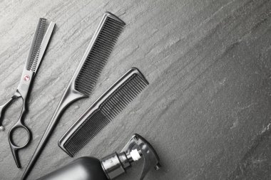 Siyah masada farklı berber aletleri var, düz yerde. Metin için boşluk