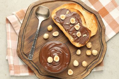 Lezzetli çikolatalı tostlar ve fındıklar ışık masasında.