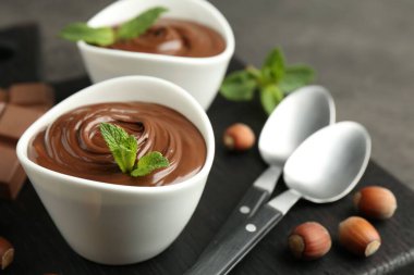 Lezzetli çikolata, parçalar, nane ve fındıklar masada, yakın plan.