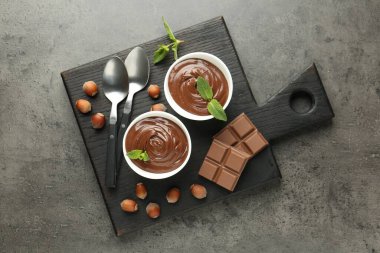 Lezzetli çikolata, parçalar, nane ve fındık, gri desenli masa, üst manzara.