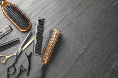 Farklı kuaförlerin aletleri karanlık masada, düz yerde. Metin için boşluk