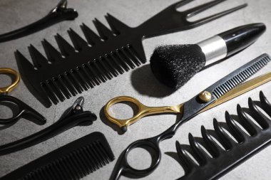 Gri masadaki farklı kuaför aletleri, yakın plan.