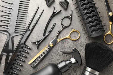 Gri masada farklı kuaförlerin aletleri var.