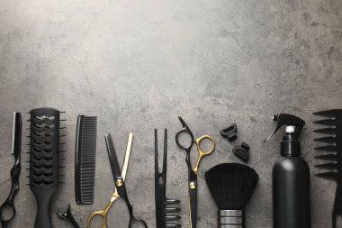 Gri masadaki farklı kuaför aletleri, düz yatış. Metin için boşluk