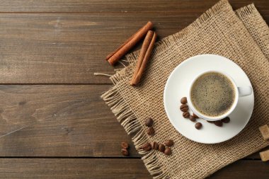 Bardakta romatik kahve, fasulye, esmer şeker ve ahşap masada tarçın, düz yatak. Metin için boşluk