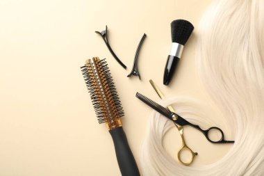 Saç tokası ve bej arka planda farklı kuaför aletleri. Metin için boşluk