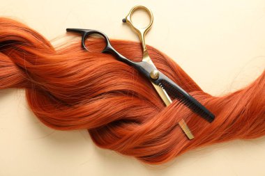 Bej arka planda saç kilidi ve makas, üst görünüm