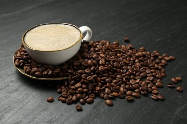 Kahve fincanda, fasulye siyah masada, yakın plan.