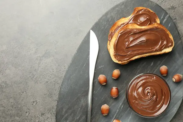 Lezzetli çikolatalı tostlar ve gri desenli masada fındıklar, üst manzara. Metin için boşluk