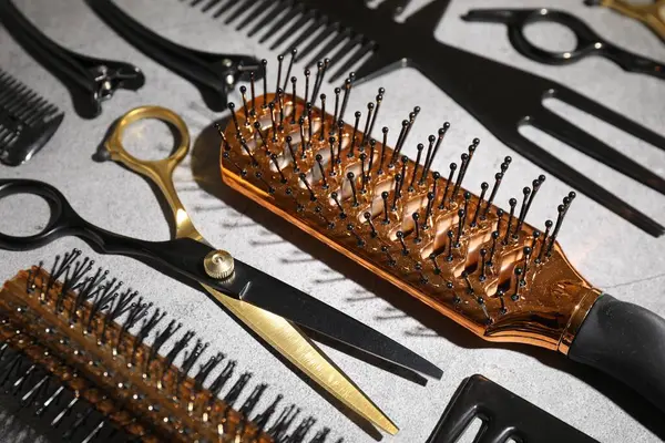 Gri masadaki farklı kuaför aletleri, yakın plan.