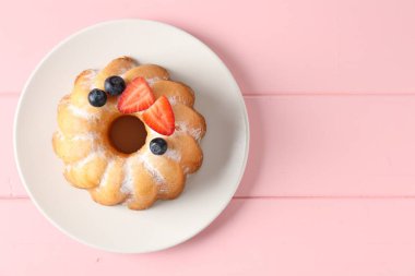 Pudra şekeri ve böğürtlenli, pembe ahşap masa manzaralı Lezzetli kek. Metin için boşluk