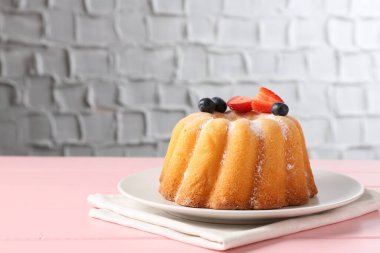 Pembe ahşap masada pudra şekeri ve böğürtlenli Lezzetli kek, yakın plan. Metin için boşluk