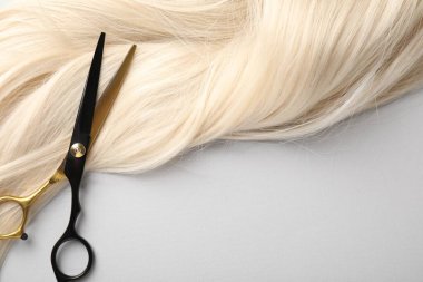 Sarı saç tokası ve makas açık gri arka plan, üst görünüm