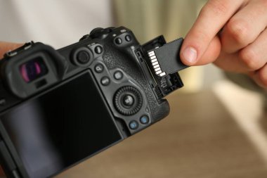 SD bellek kartını fotoğraf makinesine yerleştiren adam, kapat