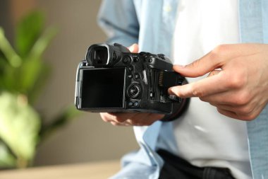 Bir adam fotoğraf makinesine SD bellek kartı yerleştiriyor.