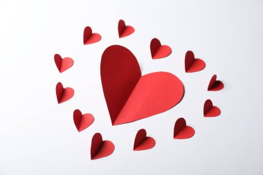 Açık gri arkaplanda bir sürü kağıt kalp