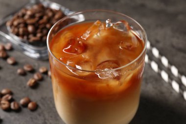 Gri masada lezzetli buzlu kahve ve fasulye, yakın plan.