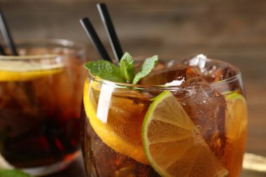 Küba libre kokteylini ahşap masada nane şekeri ile tazeliyorum.