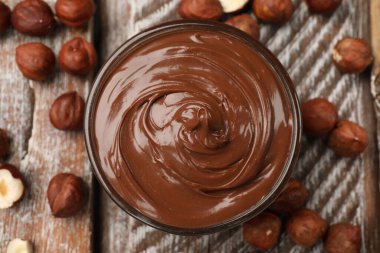 Fındıklı çikolata kâse ve fındıklar ahşap masaya serilmiş.