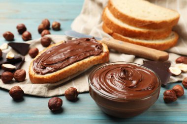 Lezzetli çikolatalı fındıklı tost ve mavi ahşap masada fındıklar, yakın plan.