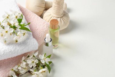 Spa ürünleri ve ince dallar beyaz masa üzerinde güzel çiçekler, yakın plan. Metin için boşluk