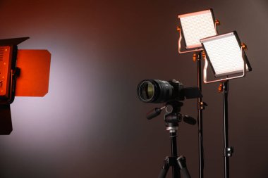 Profesyonel ışıklandırma ekipmanı ve renkli arka planda kamera. Metin için boşluk