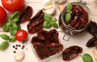 Lezzetli, kurutulmuş domatesler, taze sebzeler ve ahşap masa üzerinde biberler.