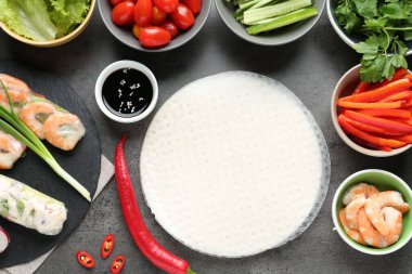 Pilav kağıtları ve farklı malzemeler koyu gri masada, düz yerde.