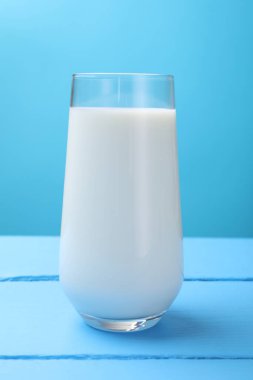 Açık mavi ahşap masada taze süt, yakın plan.